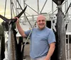 Two men are posing on a boat with a large fish they have caught