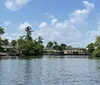 Three individuals are enjoying their time on a kayak in a scenic waterway surrounded by palm trees and waterfront properties