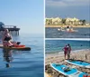 A person is paddleboarding on a calm sea with a view of a coastal city skyline in the background