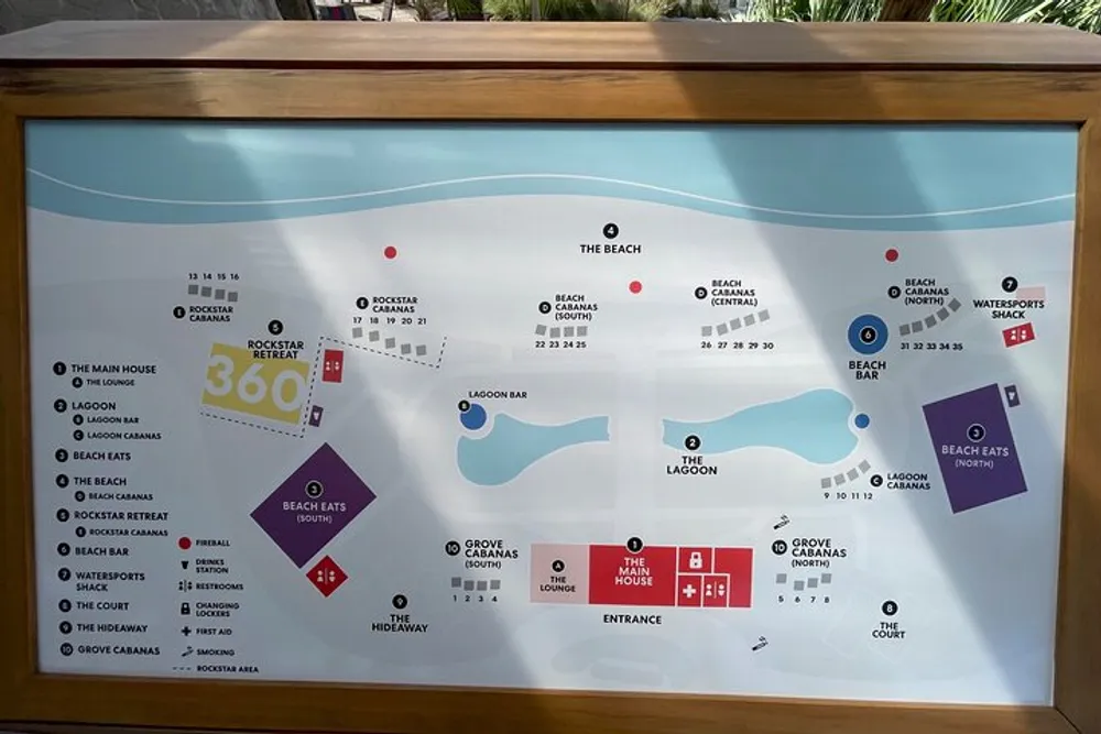 The image shows a framed map of a beach resort area with labels and icons indicating various amenities and points of interest such as a lagoon cabanas bars and a beach