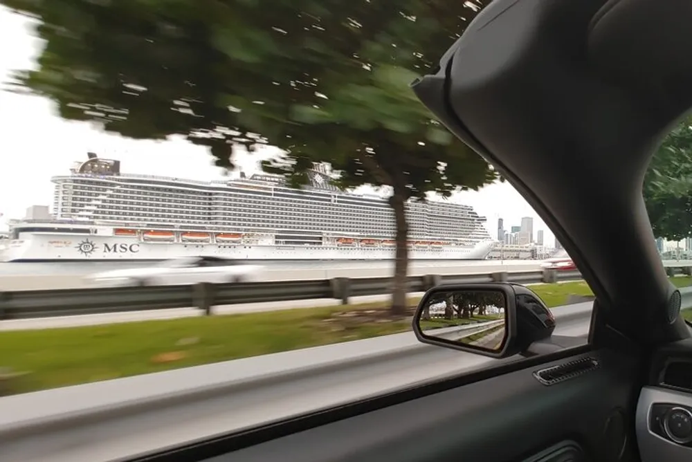 This image depicts the interior view from a moving vehicle with a large cruise ship docked in the background