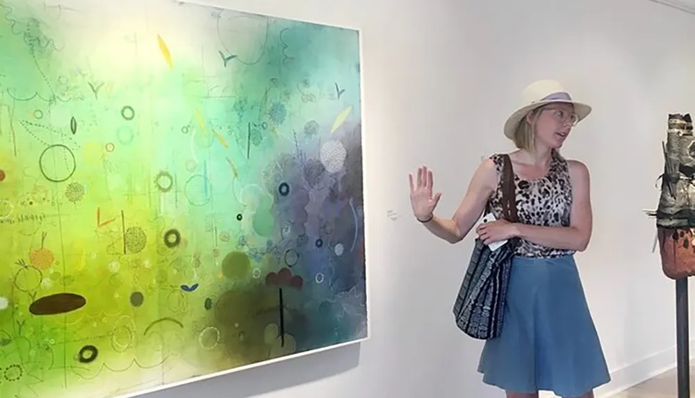 A person is admiring an abstract painting at an art gallery