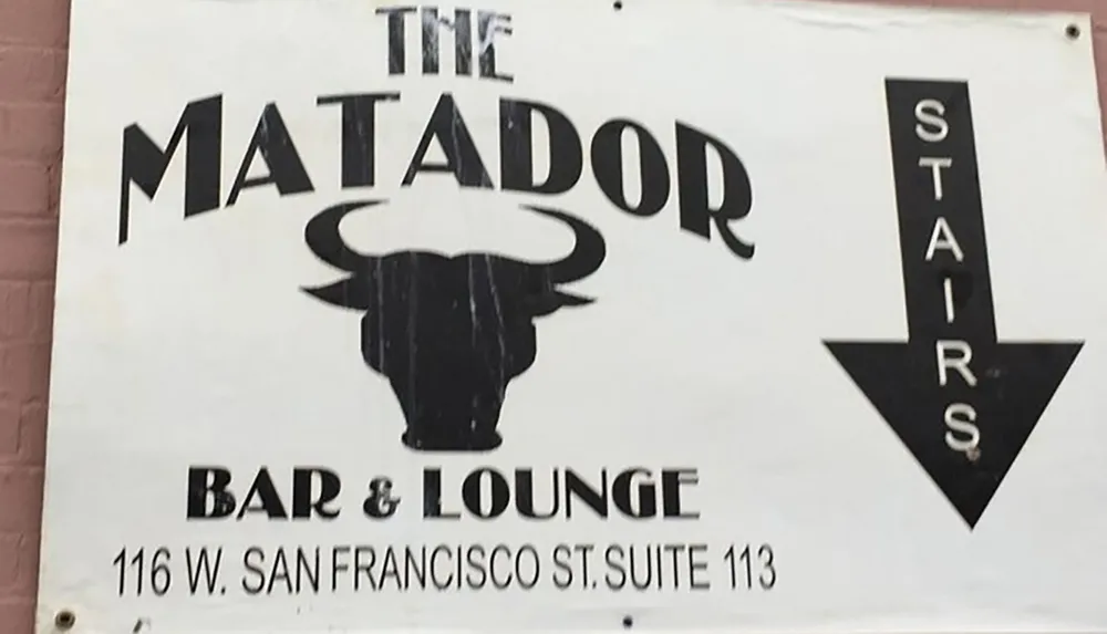 The image shows a sign for The Matador Bar  Lounge next to an arrow labeled STAIRS indicating the direction to the establishment
