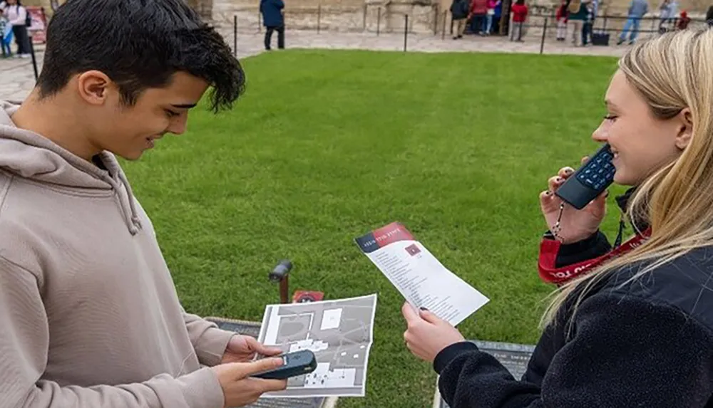 A young man and woman are looking at pamphlets and using audio guides while visiting a historical site