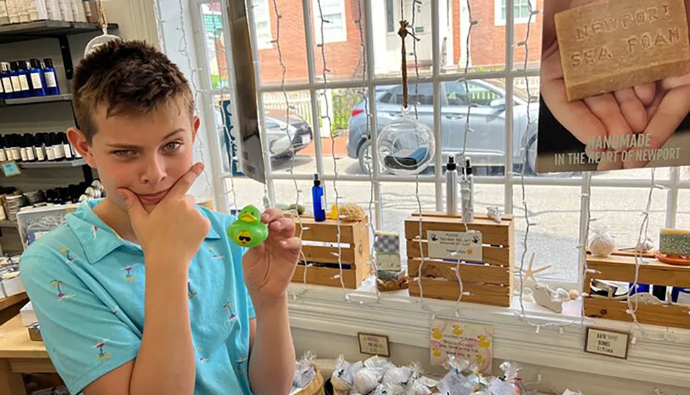 A person playfully holds a small toy and mimics its facial expression inside a shop with various handmade items on display