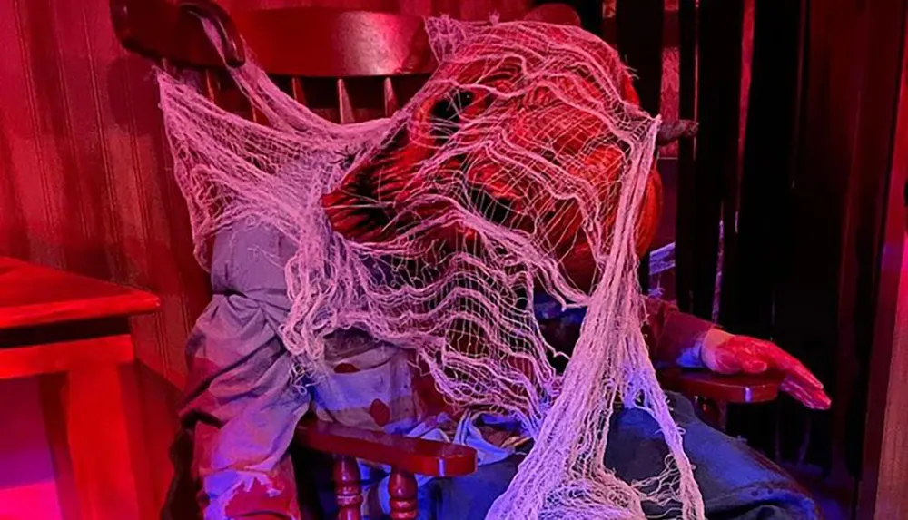 The image shows a spooky scene with a figure entangled in copious amounts of webbing creating a horror or Halloween-themed atmosphere