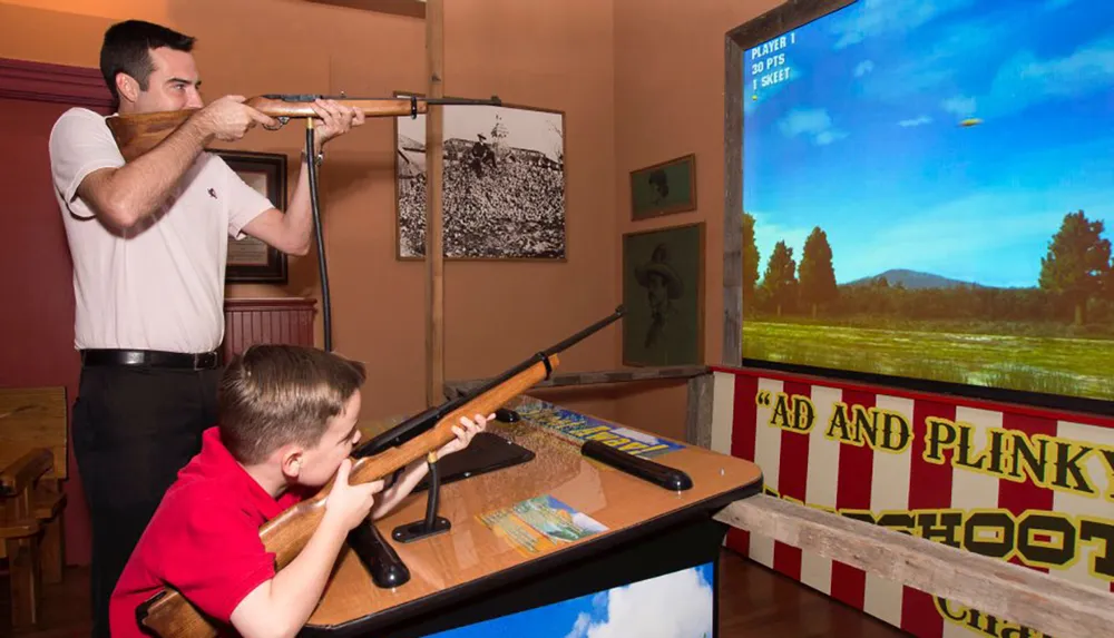 An adult and a child are playing a light gun shooter game at an arcade-style setup