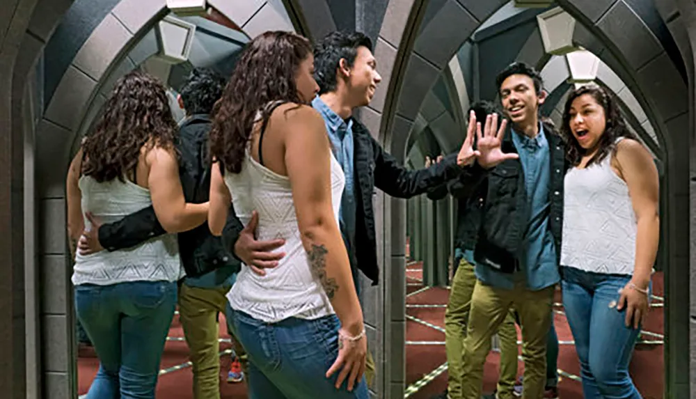 A couple interacts playfully in a mirror maze creating multiple reflections of themselves