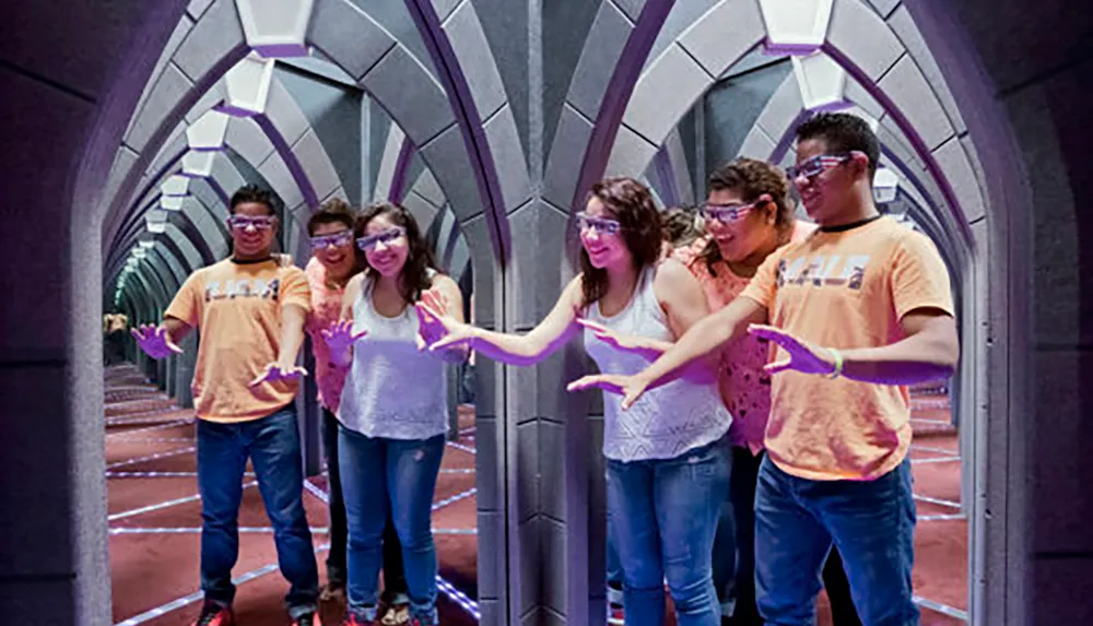 A group of people wearing 3D glasses navigates through a mirrored maze creating multiple reflections