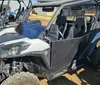 A rugged off-road vehicle is driving through a forest trail kicking up dust as it speeds along