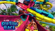 The image shows joyful people riding colorful water slides with the name 