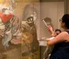 Visitors are closely examining ancient artifacts at a museum exhibit with a focus on a sarcophagus