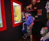 A family is enjoying their visit to a museum looking at various exhibits with a woman laughing and a child gazing at something with interest