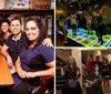 A group of people are posing happily for a photo at a table inside a bar or restaurant