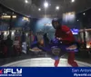 The image shows the exterior of the iFLY indoor skydiving facility during the evening with its large signage prominently displayed above the entrance