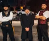 A group of people are posing for a photo in front of a bus that is advertised for a ghost tour in San Antonio