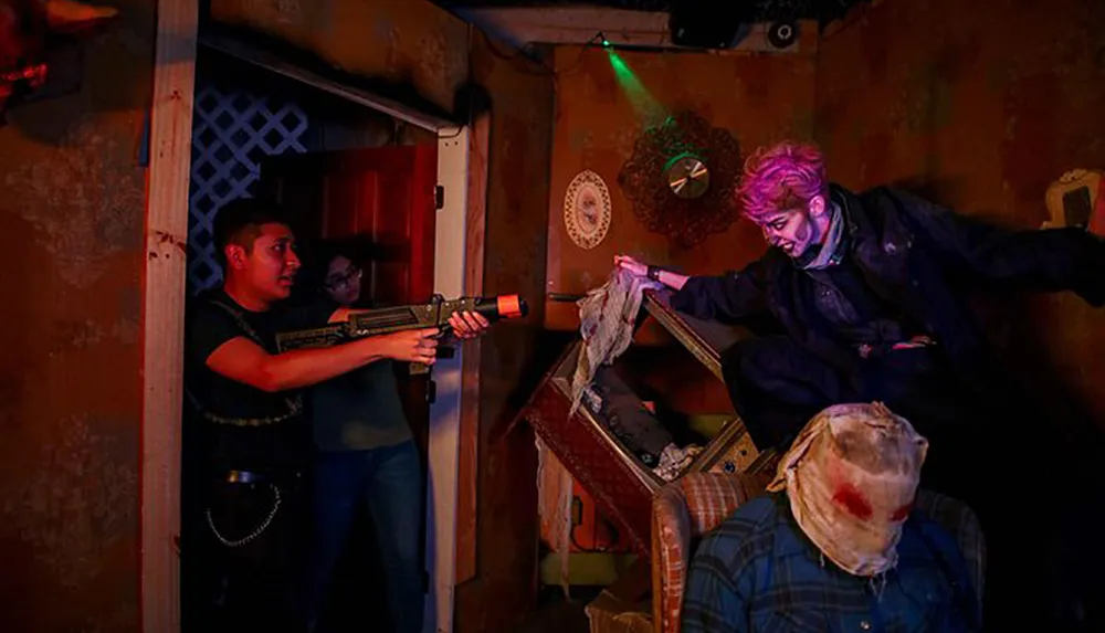 Two people appear to engage in a laser tag or an interactive theater experience aiming toy guns at a person dressed as a zombie or monster amidst a dimly lit eerie setting