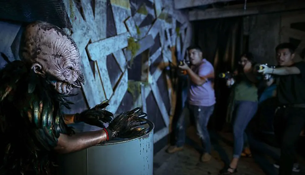 Three people with laser guns appear startled and ready to fire at a creature with a grotesque mask in what seems to be a dark thrilling laser tag or haunted attraction environment