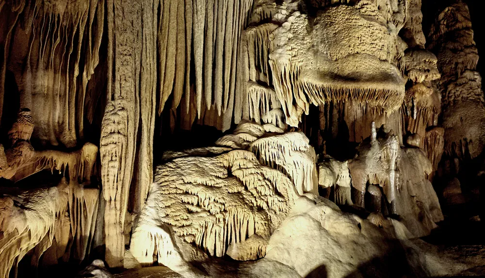 The image showcases an array of stalactites and stalagmites forming intricate natural sculptures in a dimly lit cave