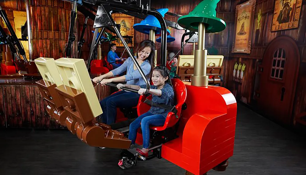 An adult and a child are enjoying a ride on a mechanical simulation attraction that resembles an excavator