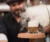 A bartender pours a smoke-infused drink creating a dramatic visual effect