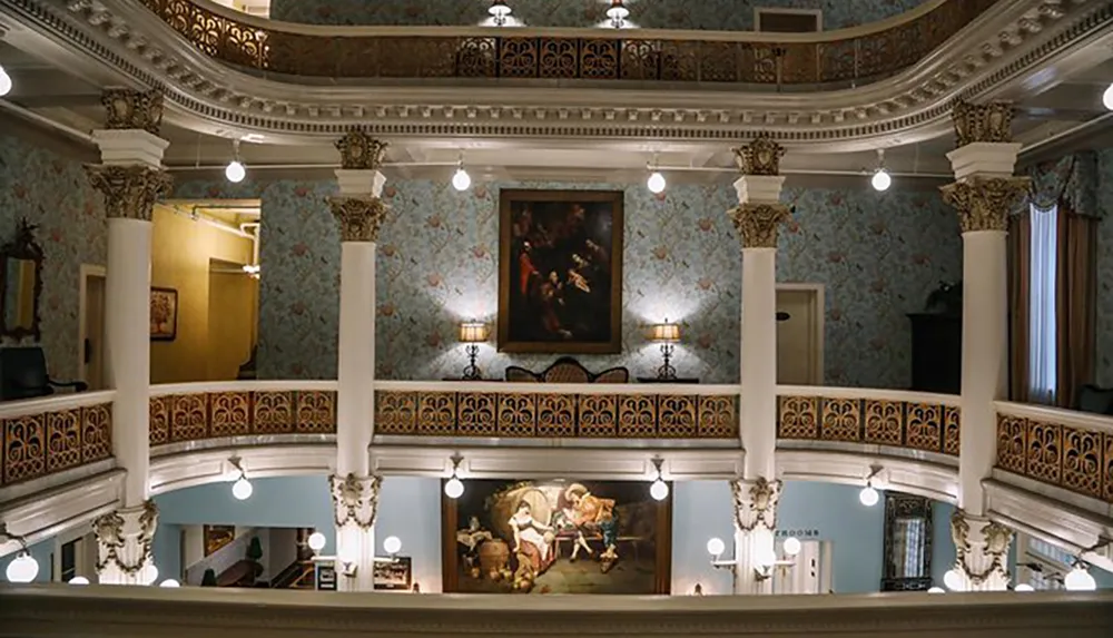 The image displays an elegantly designed interior space possibly within a historical building or museum featuring ornate columns decorative wall patterns and classical paintings