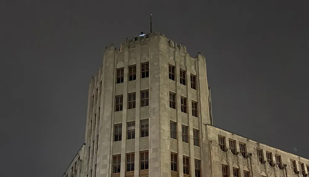 The image shows the upper portion of an ornate Gothic-style building against a dark night sky