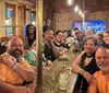 A group of smiling people are enjoying each others company at a bar with drinks creating a lively and convivial atmosphere