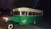A vintage-style green and white tour bus labeled 