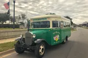 A vintage-style green and white tourist bus with 