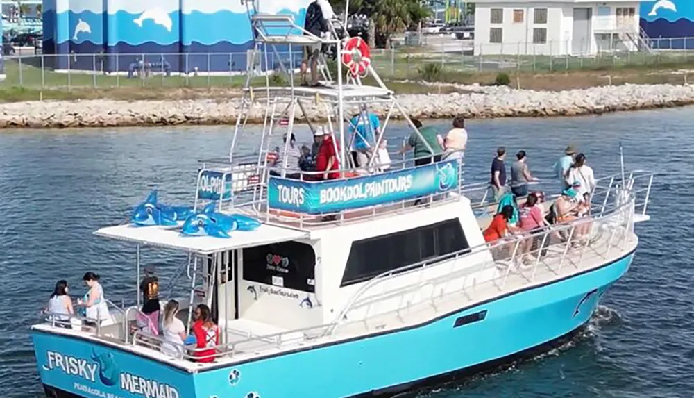 A group of individuals is aboard a bright blue Frisky Mermaid tour boat possibly preparing for or engaging in a dolphin-watching experience as indicated by the dolphin symbols and text on the boat
