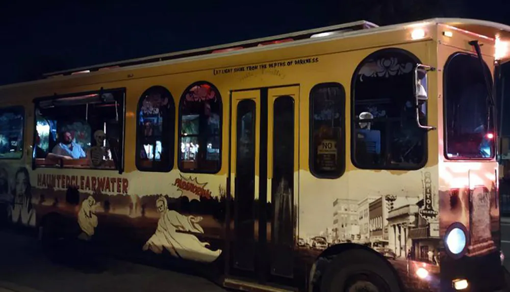 A decorated bus offering a haunted tour experience at night illuminated with string lights