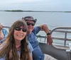 A group of people appears to be enjoying a boat trip on calm waters with a clear sky overhead