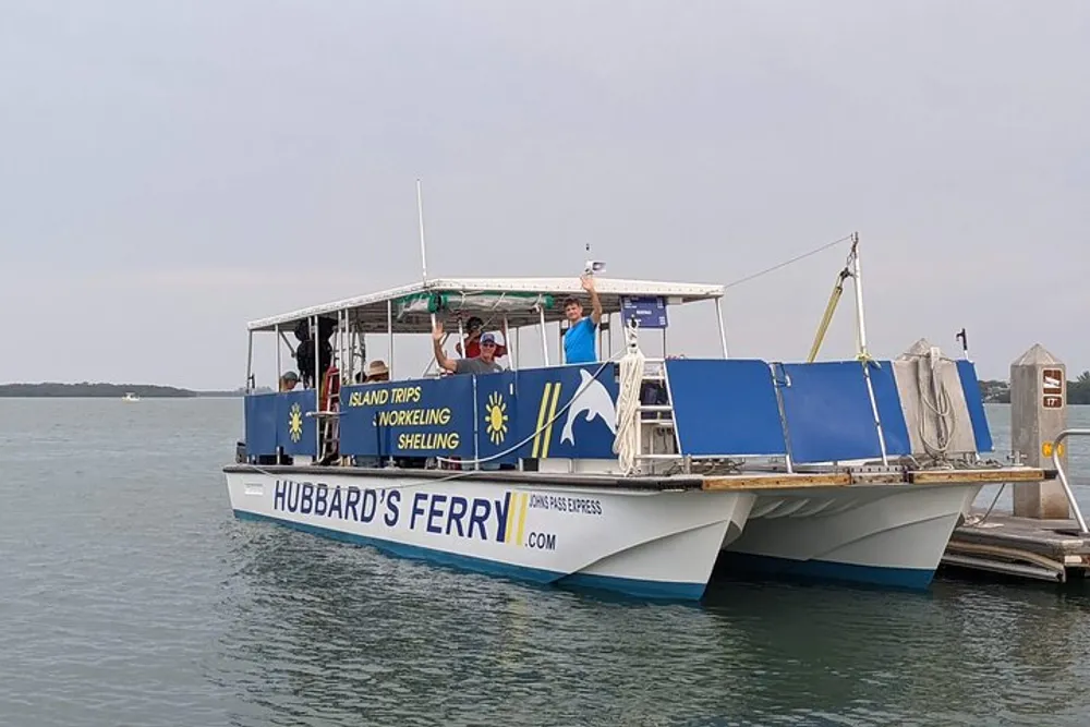 A ferry boat named HUBBARDS FERRY advertising island trips snorkeling and shelling is docked with passengers on board