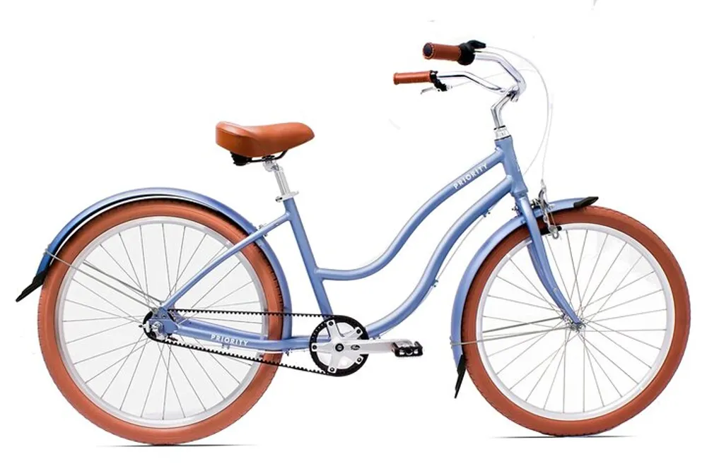The image shows a side view of a stylish blue bicycle with a brown saddle and grips equipped with a chain guard and fenders against a white background