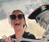 Two people are smiling and posing next to a skeleton figure in front of a trolley-style vehicle that advertises a Mystery Tour Crawl