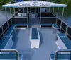 A group of people are enjoying a sunny day on a Coastal Cruises tour boat