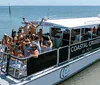 A group of people are enjoying a sunny day on a Coastal Cruises tour boat