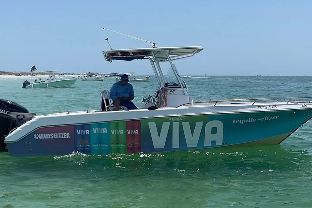 A person is sitting on a boat with advertising graphics for VIVA tequila seltzer on the side floating on clear green water