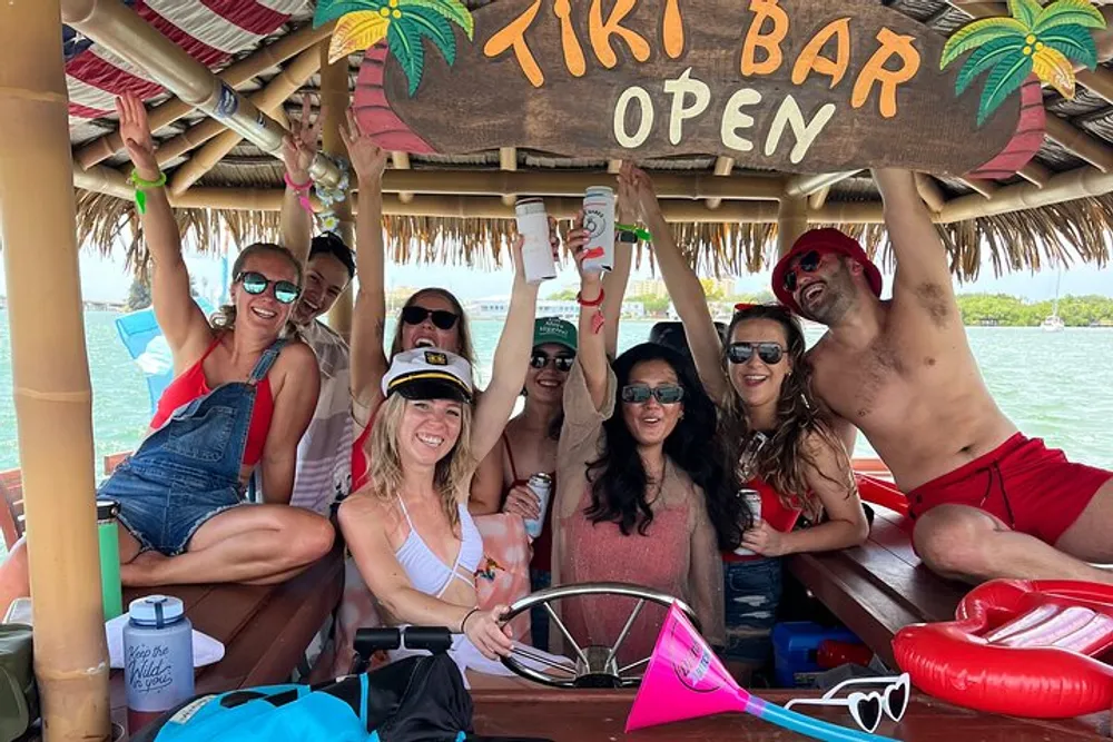 A group of cheerful people is having a fun time at a floating tiki bar on the water