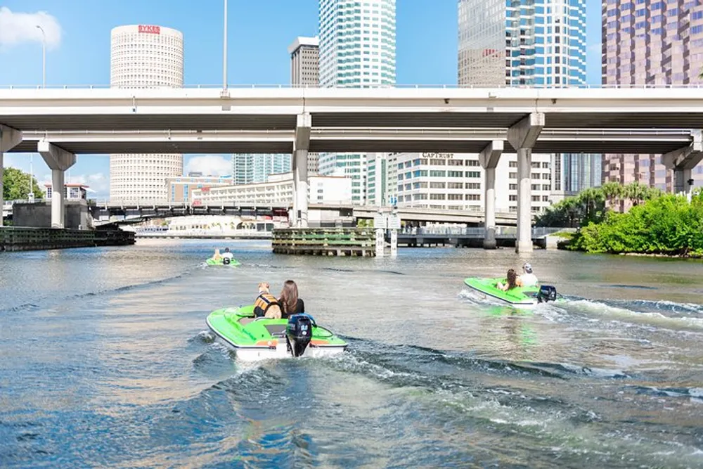 This image depicts a group of people enjoying a sunny day on jet skis in an urban river with bridges above and city buildings in the backdrop