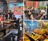 A group of people are smiling and posing for a photo in a colorful restaurant with artwork on the walls and food on their tables