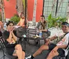 A group of people are smiling and posing for a photo in a colorful restaurant with artwork on the walls and food on their tables