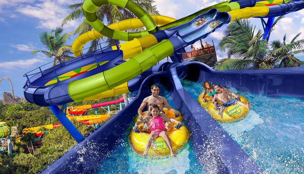People are enjoying a ride on colorful water slides at a vibrant tropical water park
