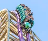 A man and a woman are joyfully riding down a water slide at a water park with splashes of water around them