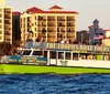 A colorful tour boat named THE TROPICS BOAT TOURS is cruising near the shore with passengers on board and American flags flying in the background