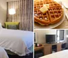 This image shows a tidy hotel room with two made-up beds bedside lamps and a green accent chair