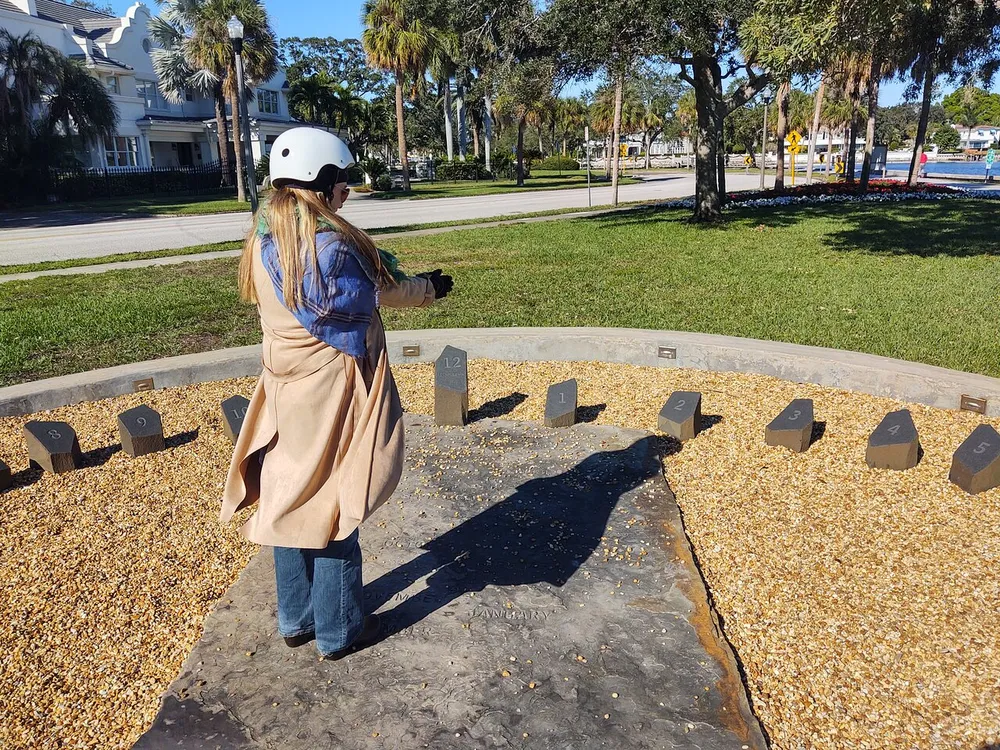 A person is experiencing virtual reality in an outdoor setting with numbered markers arranged in a semi-circle