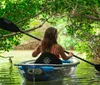 A person is kayaking through a tranquil waterway surrounded by lush greenery