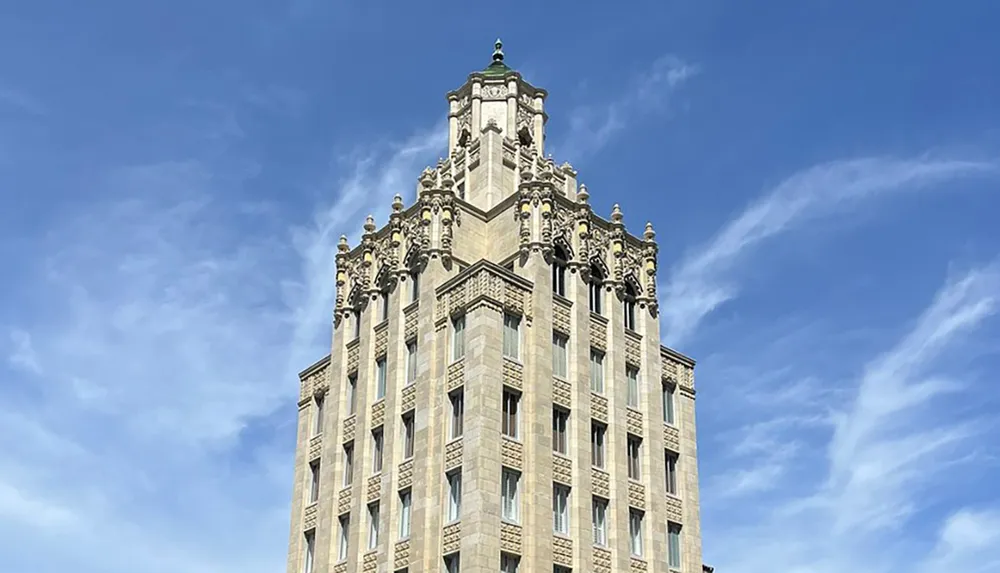 The image shows the upper part of an ornate historic high-rise building against a clear blue sky